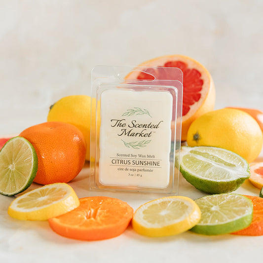 Scented wax melt packaging with citrus fruits on a light background