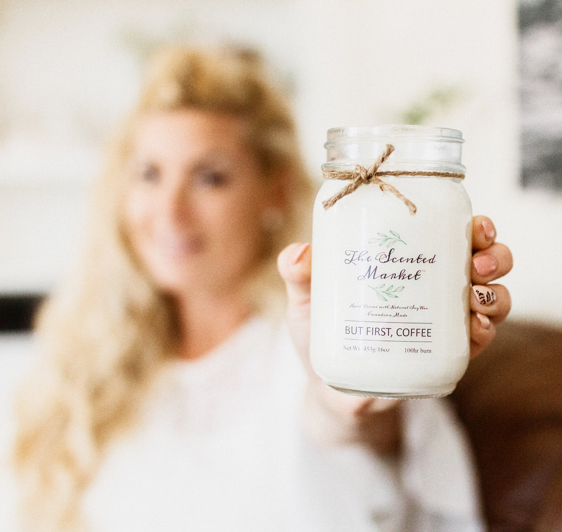 Kristy Miller CEO of The Scented Market holding a soy candle
