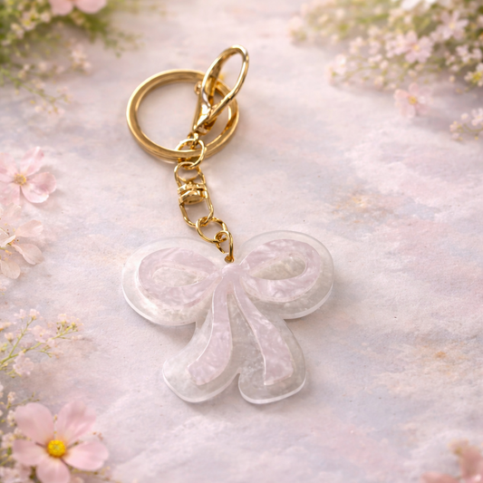 Keychain with a white floral design on a soft, floral background