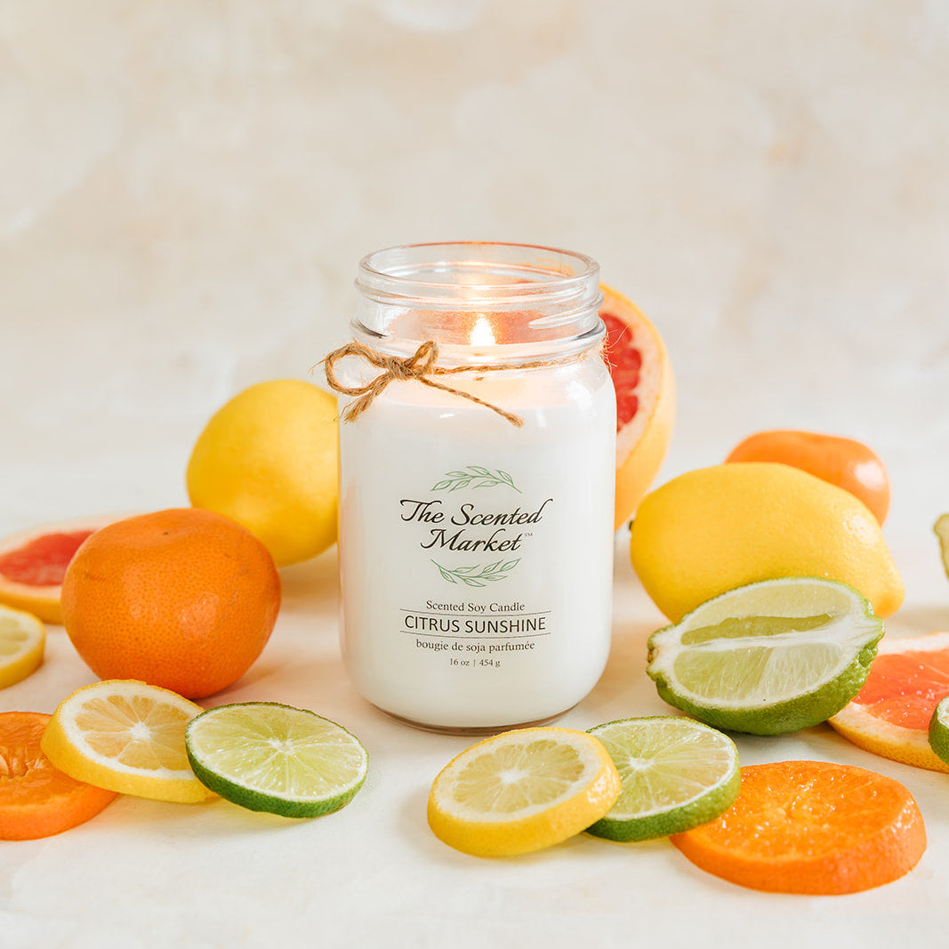 Jar of candle with citrus fruits on a light background