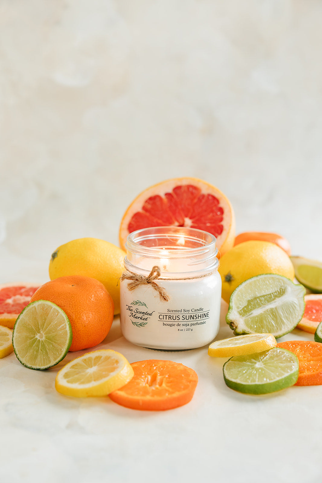 Candle with citrus fruits on a light background