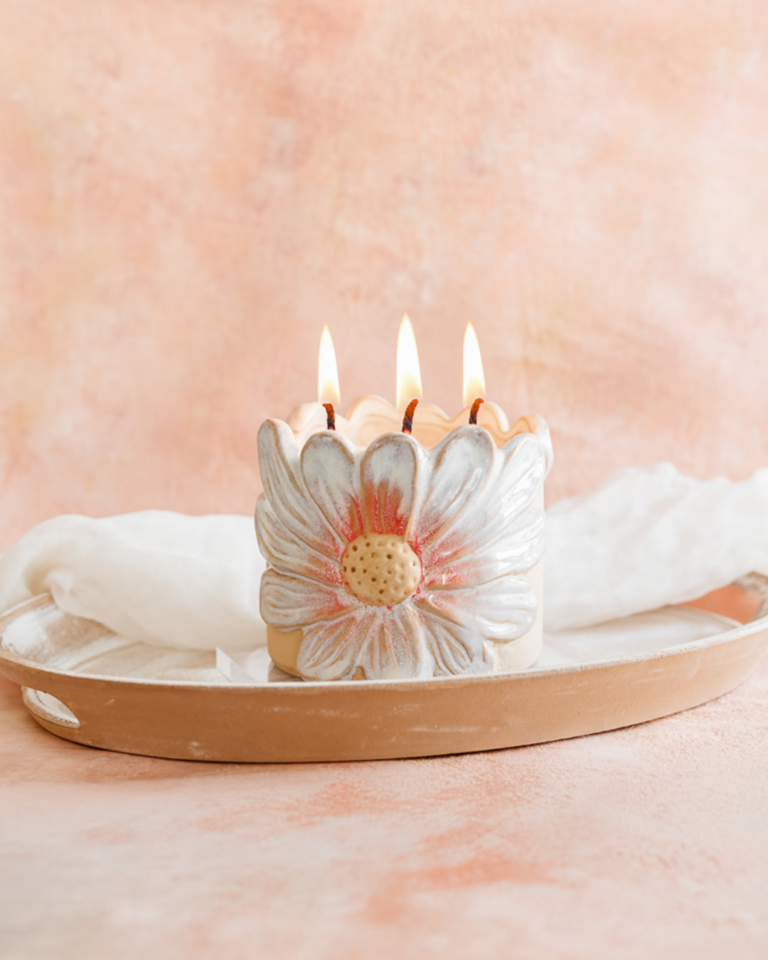 Candle with a floral design on a pink background