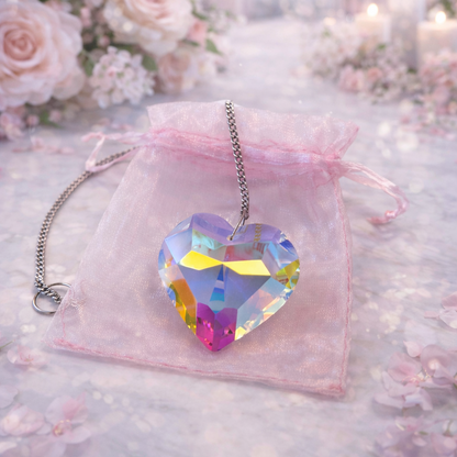 Heart-shaped colorful crystal necklace on a pink velvet bag with floral background