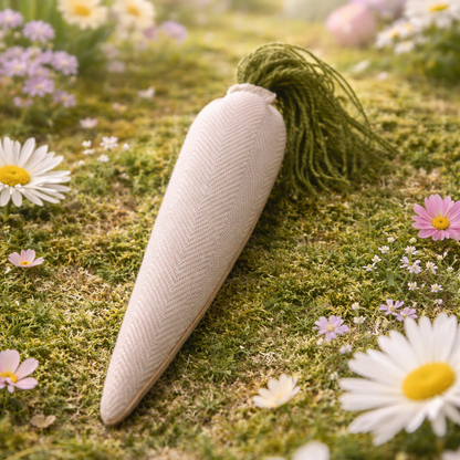 White carrot-shaped object on a grassy field with flowers