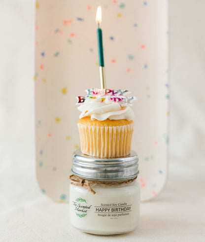 Candle with a cupcake and lit candle on top against a polka dot background